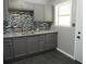 Updated kitchen features granite countertops, stylish tile backsplash, and gray cabinets at 3086 Lone Oak Sw Ave, Atlanta, GA 30354