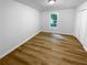 Bedroom with neutral walls, wood flooring, and a window providing natural light at 355 Marietta Hwy, Roswell, GA 30075
