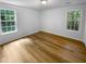 Sunny bedroom showcasing wood flooring and multiple windows with bright light at 355 Marietta Hwy, Roswell, GA 30075