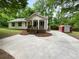 Charming home with front porch and a concrete driveway surrounded by green trees and a storage shed in the back at 355 Marietta Hwy, Roswell, GA 30075
