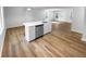 Kitchen island with stainless steel sink and dishwasher, plus white cabinets and hardwood floors at 355 Marietta Hwy, Roswell, GA 30075