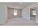 An empty bedroom with neutral carpeting, a window, and a doorway leading to another room at 124 Felicity Pike, Locust Grove, GA 30248