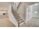 Open staircase featuring wood treads, iron spindles, luxury vinyl plank flooring and natural light at 124 Felicity Pike, Locust Grove, GA 30248
