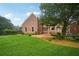 Spacious backyard with brick patio, mature trees, and lush green lawn at 230 Summerhouse Ln, Atlanta, GA 30350