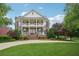 Beautiful two-story brick home featuring a double porch, manicured lawn and mature trees at 230 Summerhouse Ln, Atlanta, GA 30350