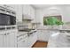 Bright kitchen with white cabinetry, granite countertops, and stainless steel appliances, offering a modern design at 230 Summerhouse Ln, Atlanta, GA 30350