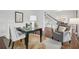 Bright office area with dark wood floors, a modern desk setup, and comfortable seating near the stairway at 230 Summerhouse Ln, Atlanta, GA 30350