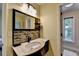 The powder room features a marble countertop, mosaic backsplash, and modern fixtures at 9440 Knollcrest Blvd, Alpharetta, GA 30022