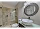 Stylish bathroom with a tiled shower, a unique vessel sink, and a modern round mirror at 9440 Knollcrest Blvd, Alpharetta, GA 30022