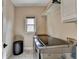 Well-lit laundry room with modern appliances, white cabinets, and tile floors at 9440 Knollcrest Blvd, Alpharetta, GA 30022