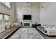 Spacious living room with high ceilings, a fireplace, neutral colored couches, and large windows at 9440 Knollcrest Blvd, Alpharetta, GA 30022