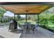 Covered patio with an outdoor dining set, ceiling fan, and a view of the lawn and backyard at 9440 Knollcrest Blvd, Alpharetta, GA 30022