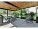 Covered patio offers an outdoor dining set, a hanging chair, a wood ceiling and backyard views at 9440 Knollcrest Blvd, Alpharetta, GA 30022