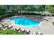 Community pool with lounge chairs, greenery, and tennis courts, perfect for relaxation and outdoor activities at 9440 Knollcrest Blvd, Alpharetta, GA 30022