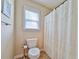 Cozy bathroom with a toilet and a shower curtain, along with natural light from the window at 176 Oakland Way, Dallas, GA 30157