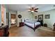 Traditional bedroom with a ceiling fan, adjacent to an open doorway and a view of the staircase at 176 Oakland Way, Dallas, GA 30157