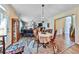 Open dining area with chandelier, hardwood floors, leading to living room and stairwell creates inviting space at 176 Oakland Way, Dallas, GA 30157