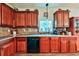Kitchen with wooden cabinets, tile backsplash, and a window above the sink at 176 Oakland Way, Dallas, GA 30157