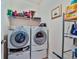 Practical laundry area featuring a stacked washer and dryer with shelving for storage solutions at 176 Oakland Way, Dallas, GA 30157