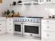Modern kitchen featuring a professional grade gas range and oven with stainless steel hood and white cabinets at 2200 Upper Burris Rd, Canton, GA 30114
