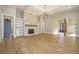 Spacious living room with stone fireplace, built-in bookshelves, coffered ceiling, modern chandelier, and gleaming hardwood floors at 2200 Upper Burris Rd, Canton, GA 30114