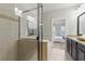 Elegant bathroom with glass-enclosed shower, soaking tub, and vanity with granite countertop at 2828 Broughton Se Ln, Atlanta, GA 30339