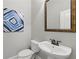 Elegant half-bathroom with a pedestal sink, modern fixtures, and stylish blue wall art at 2828 Broughton Se Ln, Atlanta, GA 30339
