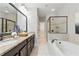 Luxurious bathroom with double vanity, granite countertop, tub, and glass-enclosed shower at 2828 Broughton Se Ln, Atlanta, GA 30339