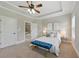 Relaxing bedroom with a tray ceiling, ceiling fan, and plush carpet. Bathroom visible through open door at 2828 Broughton Se Ln, Atlanta, GA 30339