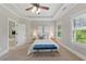 Inviting bedroom with tray ceiling, ceiling fan, and open door to bathroom with tub at 2828 Broughton Se Ln, Atlanta, GA 30339