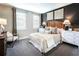 Inviting bedroom featuring a cozy bed, soft carpet, and natural light from the windows at 3351 Orwell Way # 2305, Cumming, GA 30041