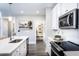 Well-lit kitchen featuring a large island with seating, stainless appliances, and pantry view at 3351 Orwell Way # 2305, Cumming, GA 30041