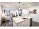 Open-concept kitchen and living area with island seating, stainless appliances, and bright lighting at 3351 Orwell Way # 2305, Cumming, GA 30041
