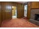 Cozy living room featuring wood paneled walls, brick fireplace, and carpeted floor at 4370 Tradition Ter, Austell, GA 30106