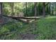 Exterior landscape of a wooded yard featuring a charming wood bridge spanning a small ditch at 4370 Tradition Ter, Austell, GA 30106