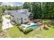 A backyard featuring a pristine pool, enclosed fence, patio furniture, and lush green landscape at 5178 Stefan Ridge Way, Buford, GA 30519