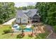 Backyard showcasing a sparkling pool, deck with stairs, screened-in porch, and manicured landscaping at 5178 Stefan Ridge Way, Buford, GA 30519