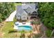 Backyard featuring a pool, deck stairs, a screened-in porch, fire pit, and lush landscaping at 5178 Stefan Ridge Way, Buford, GA 30519