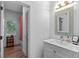Bright bathroom with a single sink vanity, decorative mirror, and wood-look floors at 5178 Stefan Ridge Way, Buford, GA 30519