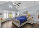Primary bedroom with vaulted ceiling, large window with backyard view, and decorative ceiling fan at 5178 Stefan Ridge Way, Buford, GA 30519