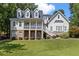 Inviting two-story home featuring a charming front porch, dormer windows, and lush landscaping at 5178 Stefan Ridge Way, Buford, GA 30519