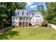 Traditional two-story home features a covered front porch, long driveway, and landscaped front yard in a wooded setting at 5178 Stefan Ridge Way, Buford, GA 30519