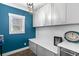 Functional laundry room with storage cabinets, quartz countertop, utility sink, and built-in bench seating at 5178 Stefan Ridge Way, Buford, GA 30519
