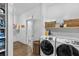 Well-lit laundry room with washer, dryer, shelving, and decor at 5178 Stefan Ridge Way, Buford, GA 30519