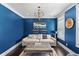 Cozy living room with blue walls, a comfortable couch, and a decorative light fixture at 5178 Stefan Ridge Way, Buford, GA 30519