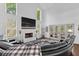 Bright living room featuring a painted brick fireplace and large sectional couch at 5178 Stefan Ridge Way, Buford, GA 30519