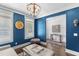 Bright living room features blue accent wall, modern light fixture, and stylish decor at 5178 Stefan Ridge Way, Buford, GA 30519