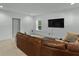 Bright living room showcasing a comfortable leather couch and large-screen TV at 5178 Stefan Ridge Way, Buford, GA 30519