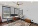 Bright home office with natural light, modern desk setup, and a ceiling fan at 5178 Stefan Ridge Way, Buford, GA 30519