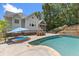 An inviting backyard pool with lounge chairs, patio seating, and a view of the screened in porch offers a relaxing outdoor space at 5178 Stefan Ridge Way, Buford, GA 30519